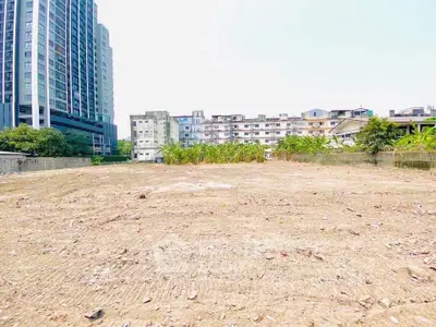 Prime urban land plot with potential for high-rise development, surrounded by cityscape and greenery.