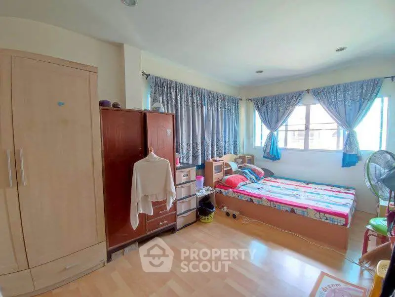 Cozy bedroom with ample natural light and wooden furniture