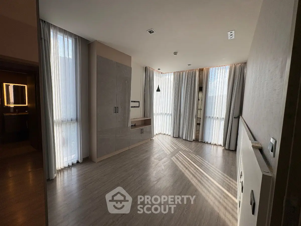 Spacious modern living room with large windows and elegant flooring