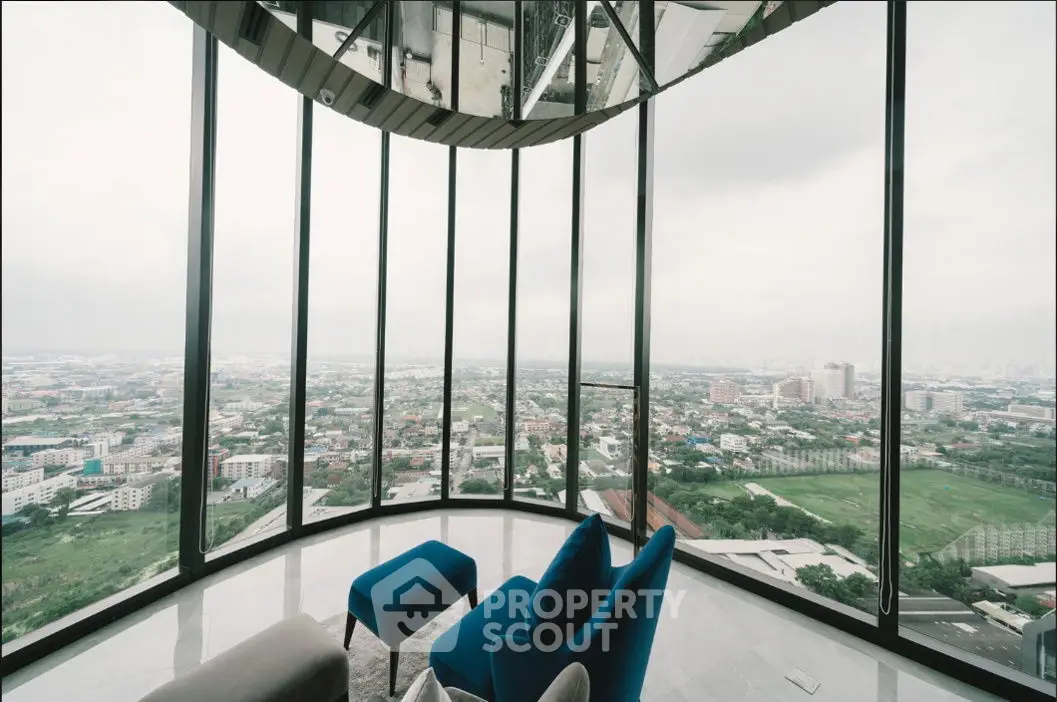 Stunning panoramic city view from modern high-rise apartment with floor-to-ceiling windows.