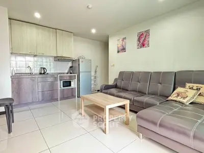 Modern living room with sleek kitchen, stylish sofa, and contemporary decor in open layout apartment.