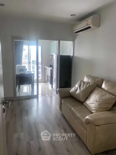 Cozy living room with modern kitchen and balcony view in a stylish apartment.