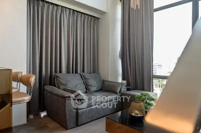 Modern living room with stylish sofa and large window offering city views.