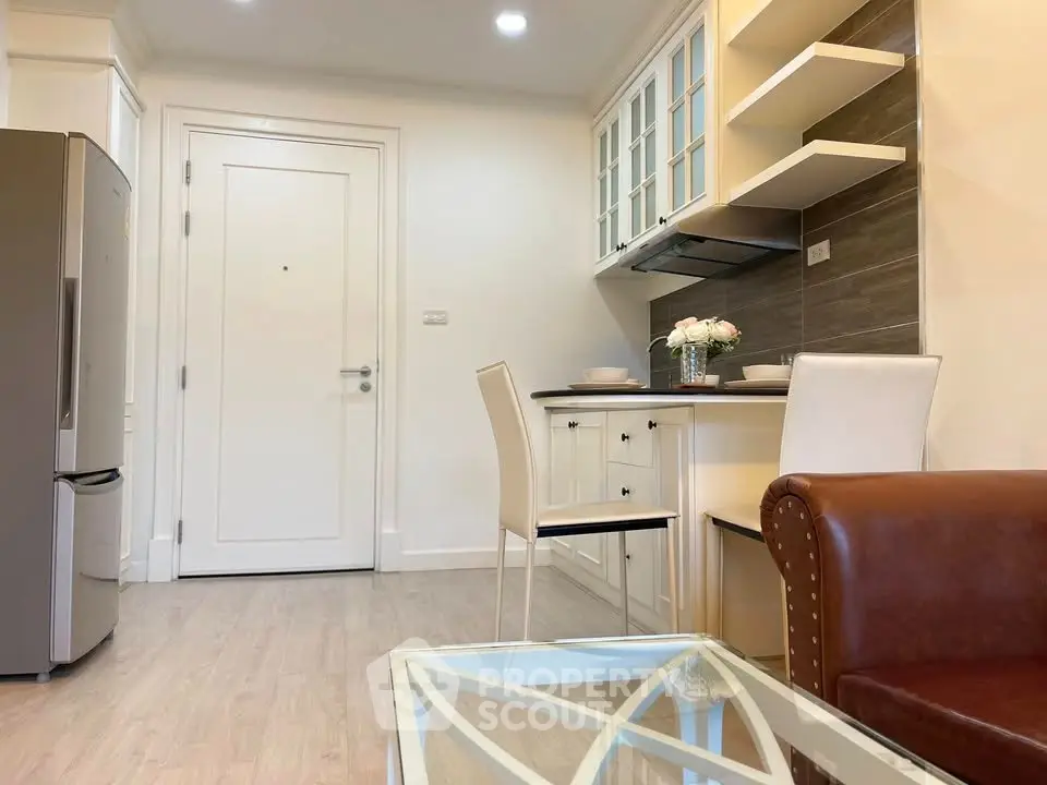 Chic modern kitchen with sleek appliances and cozy dining area in stylish apartment.