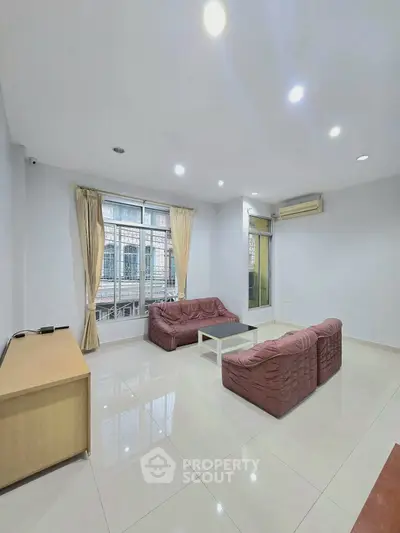 Spacious living room with modern furniture and large window offering natural light.