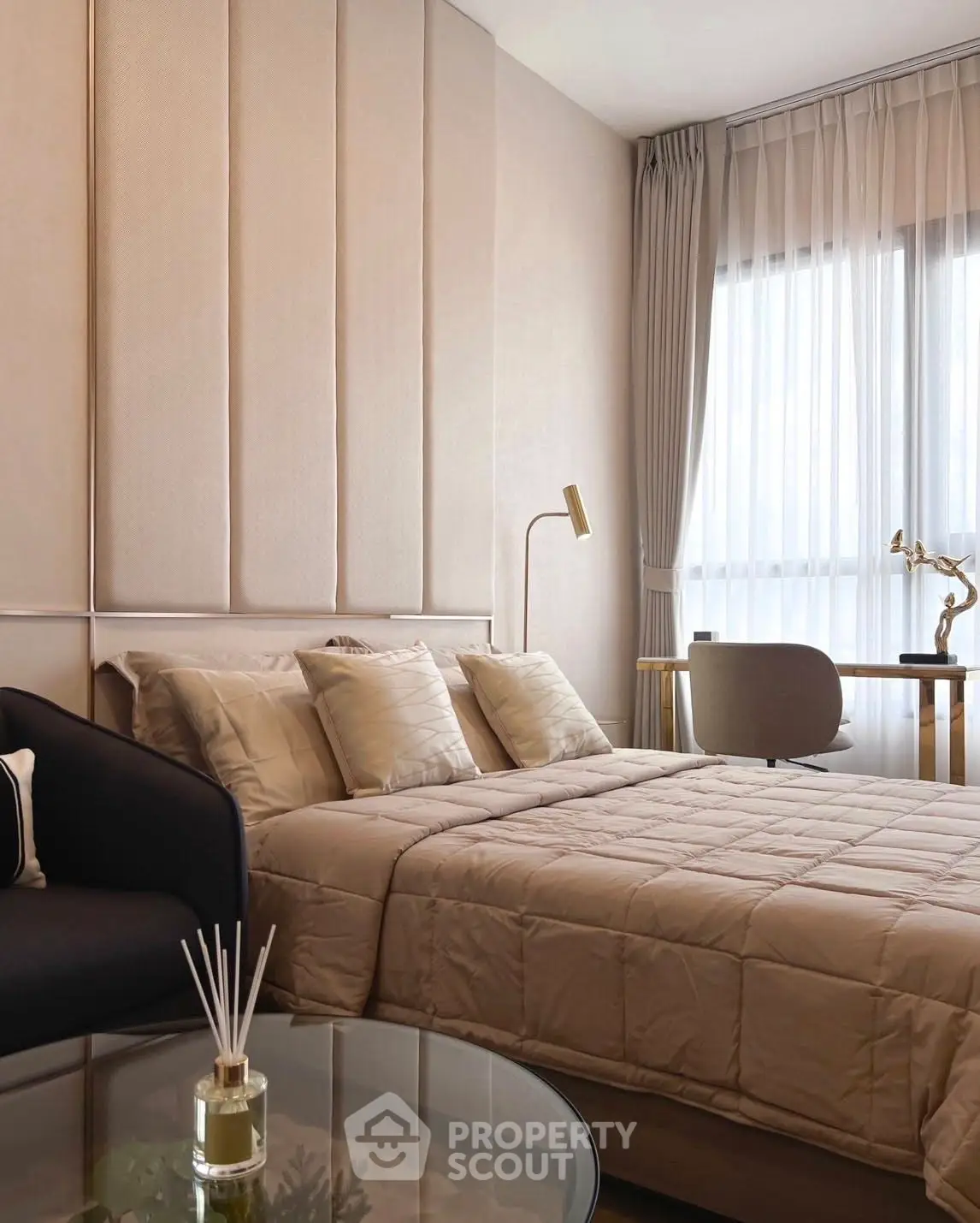 Elegant bedroom with modern decor, featuring a cozy bed, stylish chair, and natural light from large window.