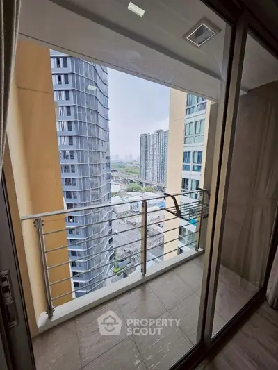 Modern high-rise balcony with stunning city view and sleek glass railing.
