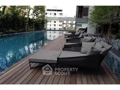 Luxurious apartment complex with stunning poolside lounge area and modern design.