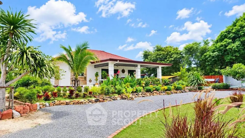 Charming single-story home with lush garden and spacious driveway under a bright blue sky.