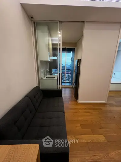 Modern apartment with sleek kitchen and cozy living area featuring a stunning city view from the balcony.