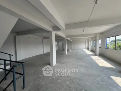 Spacious open-plan commercial space with large windows and natural light.