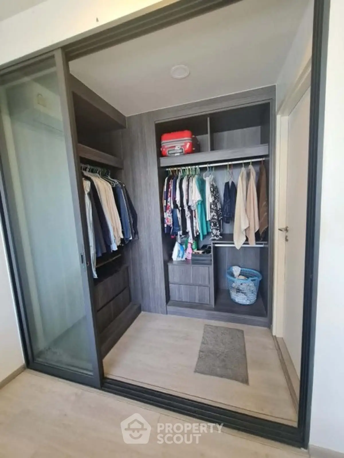 Spacious walk-in closet with modern sliding doors and ample storage space.