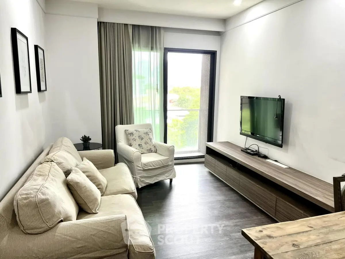 Cozy living room with modern decor and natural light, featuring a comfortable sofa and wall-mounted TV.