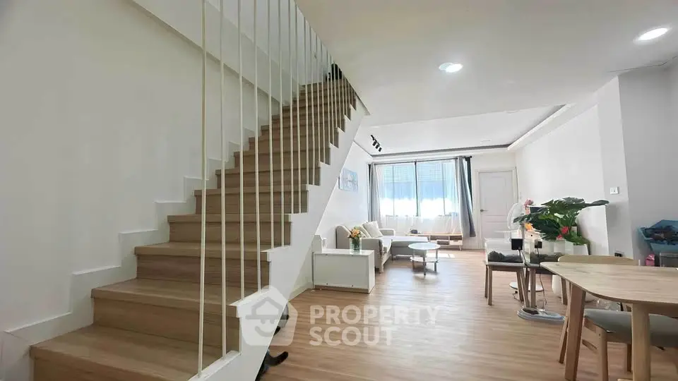 Spacious modern living room with wooden staircase and natural light