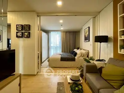 Stylish open-plan living room and bedroom with modern decor and natural light.