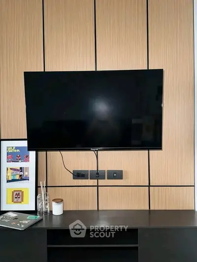 Modern living room with sleek TV setup and stylish wooden paneling.
