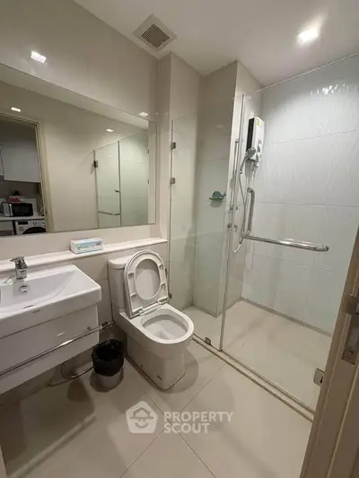Modern bathroom with glass shower and sleek fixtures in a contemporary apartment.