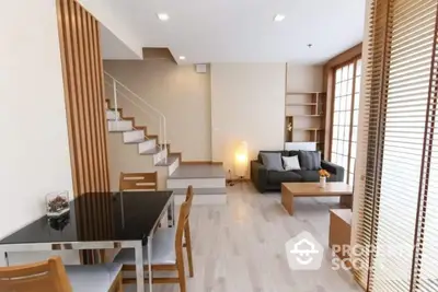 Modern living room with stylish decor and open layout, featuring wooden accents and cozy seating area.