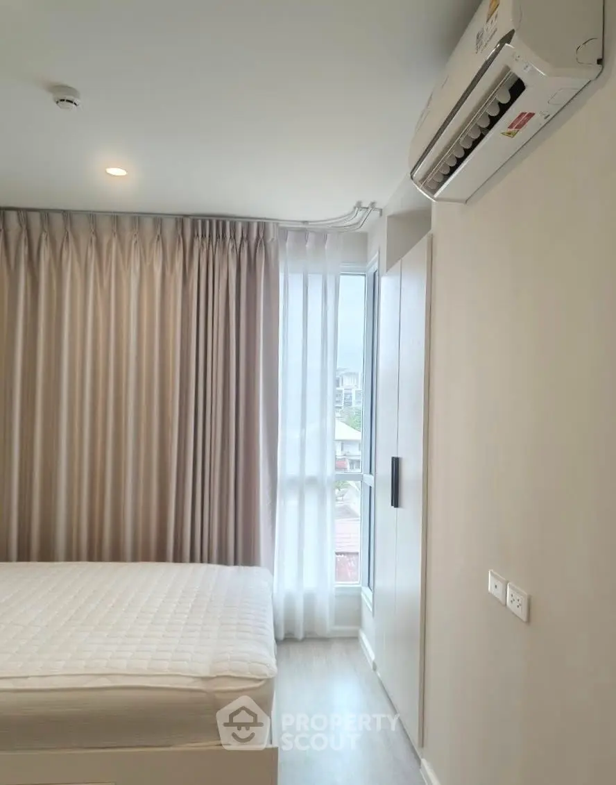 Modern bedroom with air conditioning and large window for natural light