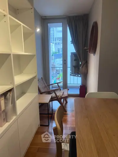 Charming living room with wooden floors, modern furniture, and a balcony view in a cozy apartment.
