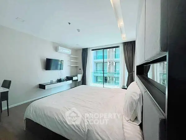 Modern bedroom with large window and stylish decor in a contemporary apartment.