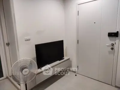 Modern minimalist living room with TV and fan, featuring sleek white decor and compact design.