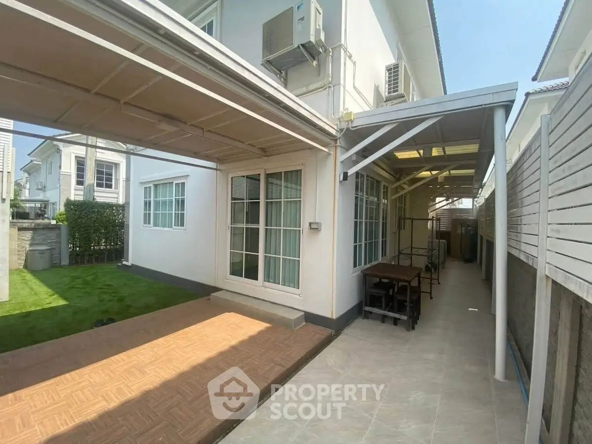 Charming suburban home with spacious outdoor patio and lush green lawn, perfect for family gatherings.