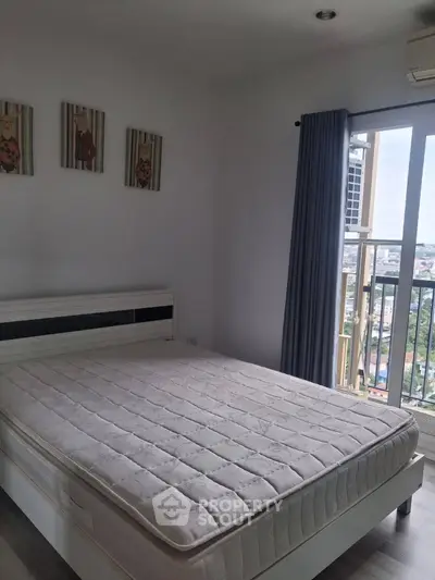 Spacious bedroom with large window offering city views, featuring a comfortable bed and modern decor.