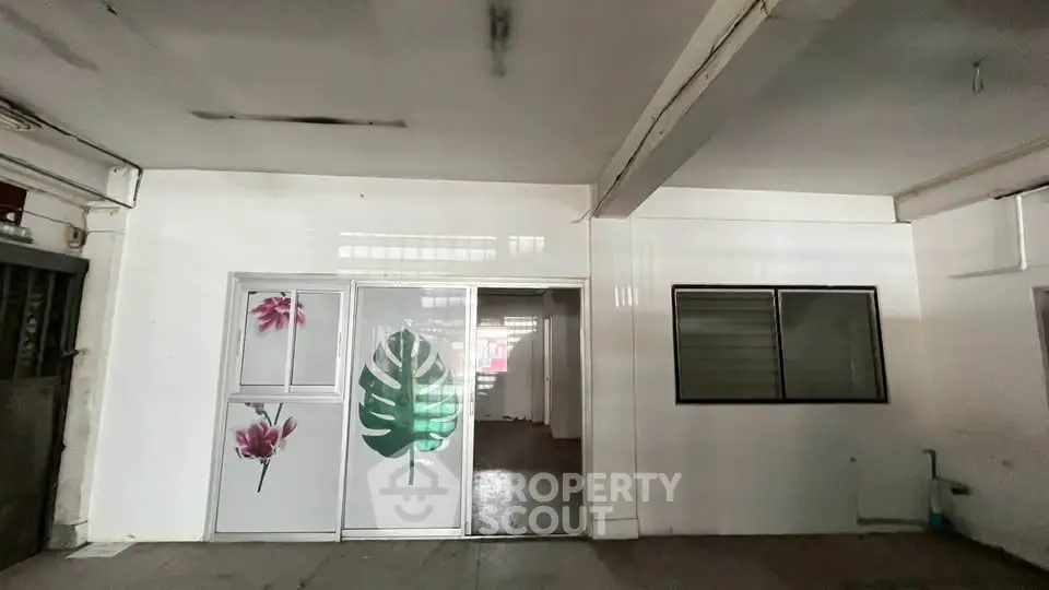 Spacious interior with unique floral door design, ideal for creative workspace or studio.