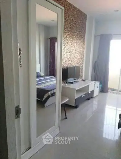 Modern bedroom with stylish decor and mirrored wardrobe in a contemporary apartment.