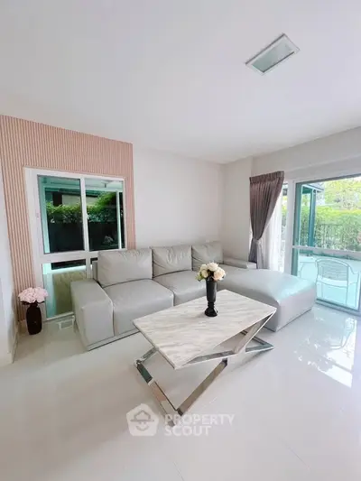 Modern living room with sleek sofa and stylish coffee table, bright and airy ambiance.