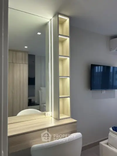 Modern bedroom with sleek built-in vanity and illuminated shelving