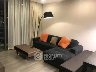 Modern living room with stylish sofa and floor lamp, perfect for relaxation.