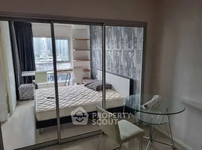 Modern bedroom with glass partition, city view, and stylish decor