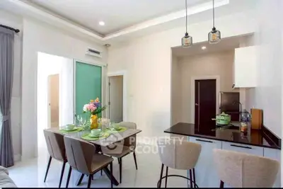 Modern dining area with elegant table setting and stylish kitchen in open layout apartment.