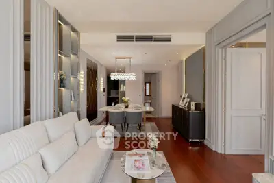 Elegant living room with modern decor and dining area, featuring stylish lighting and wooden flooring.