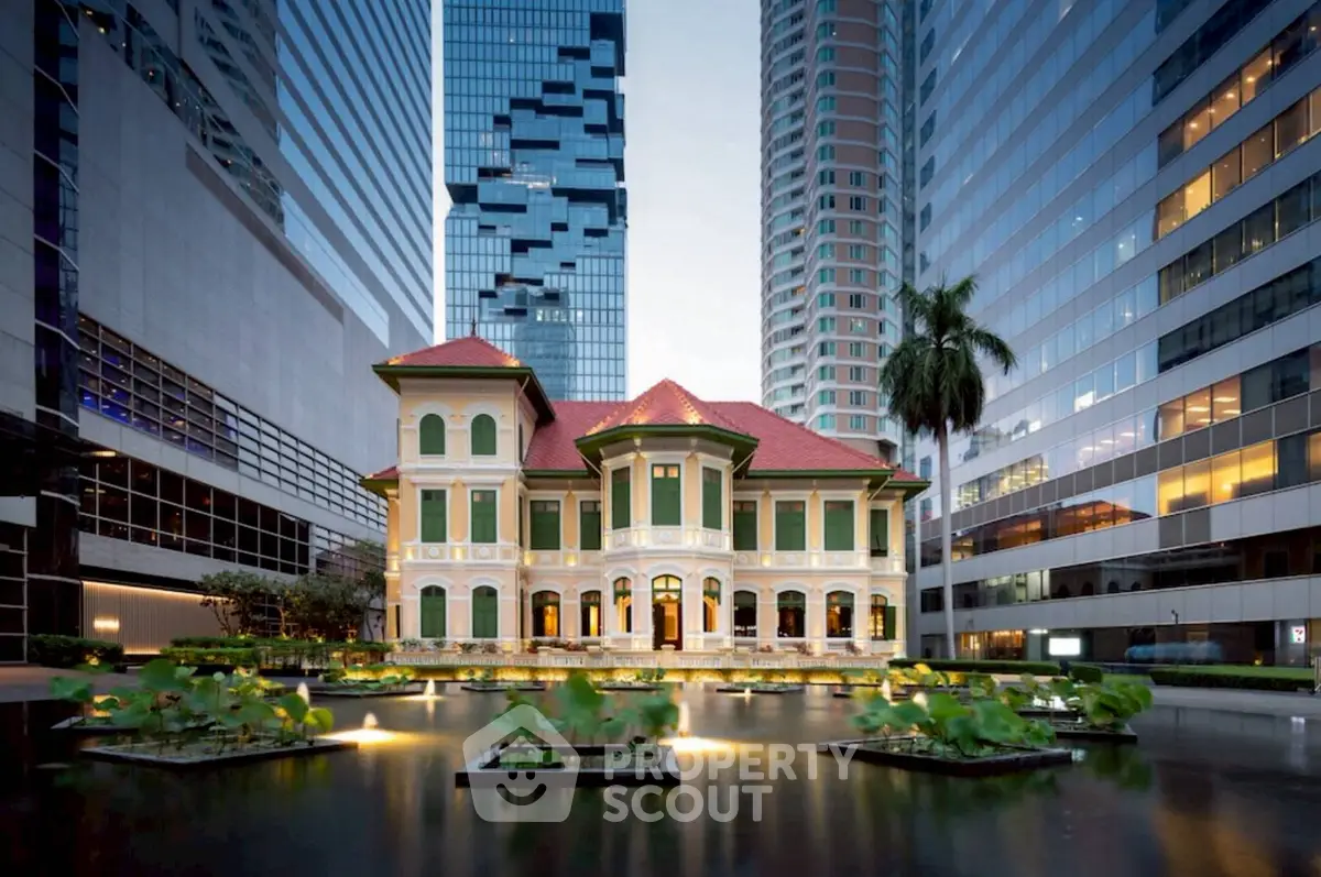 Stunning historic villa surrounded by modern skyscrapers, featuring a serene water garden in the foreground.