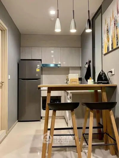 Modern kitchen with sleek design, featuring a breakfast bar, stylish lighting, and contemporary appliances.