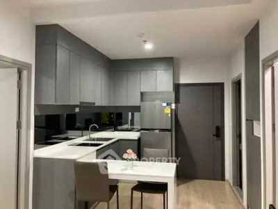 Modern kitchen with sleek gray cabinets and integrated dining area