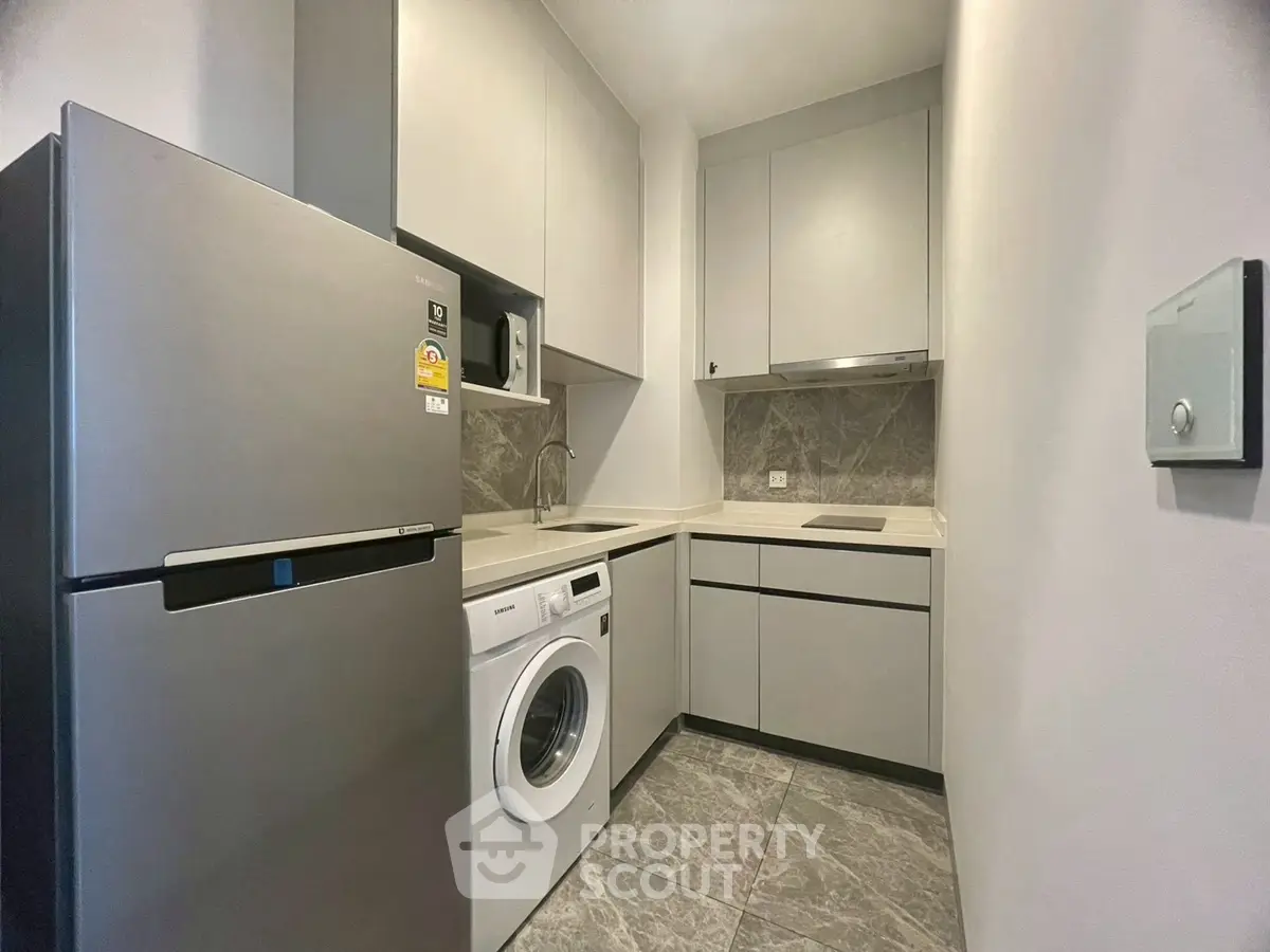 Modern compact kitchen with washing machine and sleek appliances