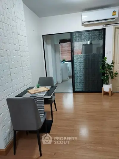 Modern dining area with sleek table and chairs, adjacent to a laundry space with washing machine.