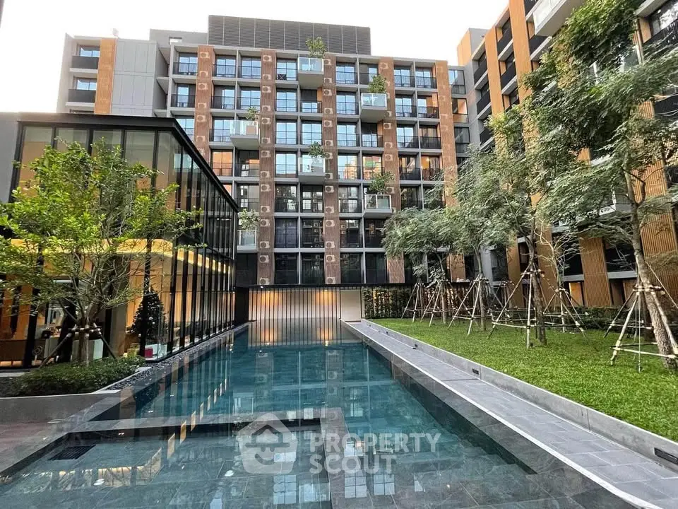 Modern apartment complex with pool and landscaped garden