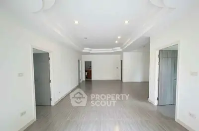 Spacious modern living room with elegant ceiling design and ample natural light.