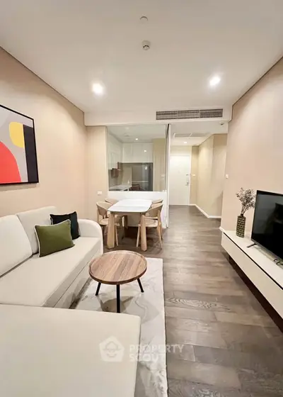 Modern living room with stylish decor and open layout, featuring a cozy sofa and dining area.