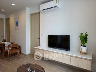 Modern living room with wall-mounted TV and air conditioning, featuring sleek wooden furniture and decor.