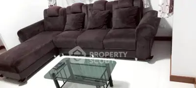 Elegant living room with plush dark sofa and glass coffee table