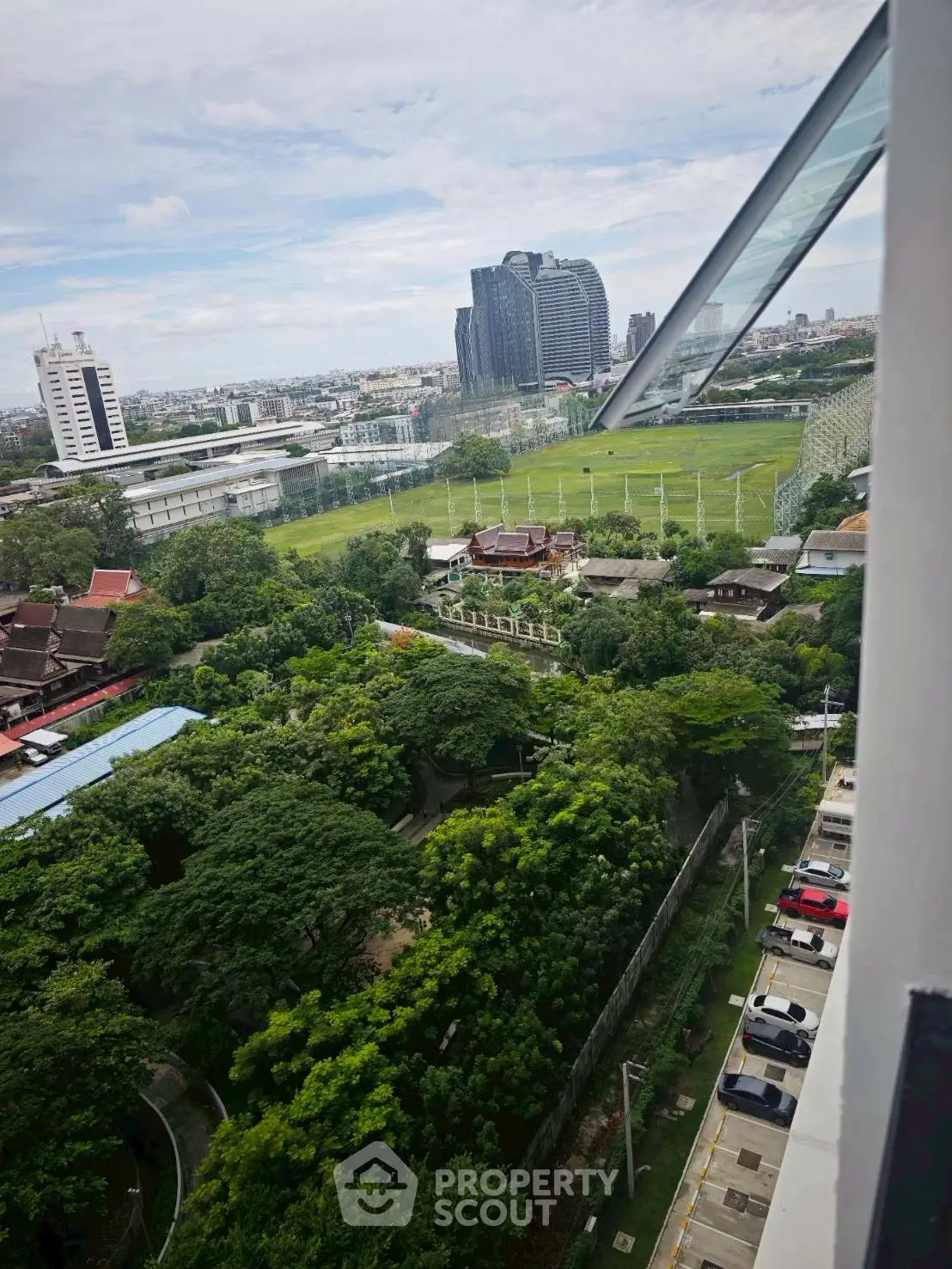 Stunning cityscape view from high-rise building with lush greenery and modern architecture.