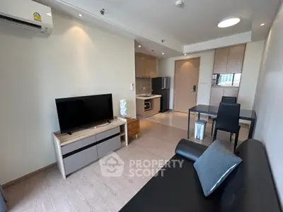 Modern living room with open kitchen layout and stylish furniture in a cozy apartment.