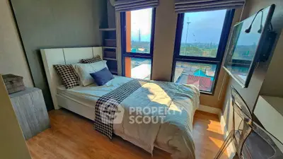 Cozy bedroom with large windows and scenic view, perfect for relaxation.