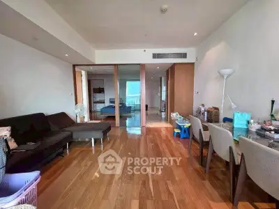 Spacious living room with wooden flooring and modern furniture in a stylish apartment.